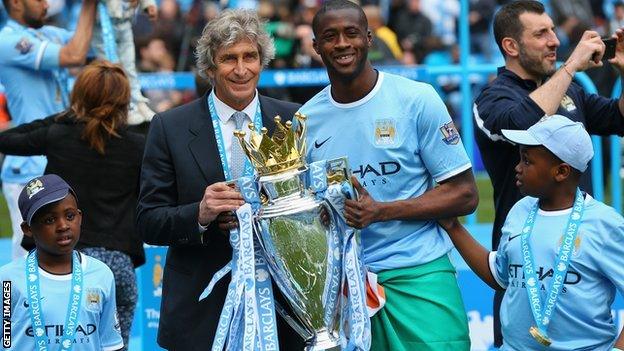 Yaya Toure (right) with Manchester City manager Manuel Pellegrini lifting the Premier Legue trophy