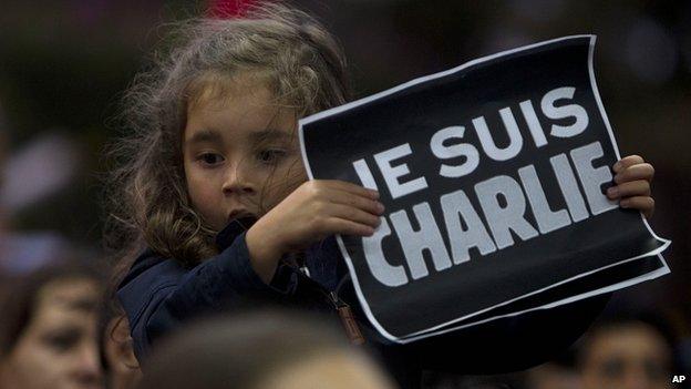 Girl holds placard at rally outside France's embassy in Guatemala City