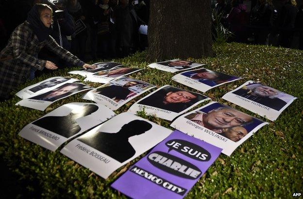 A woman places portraits of the victims outside the French embassy in Mexico City, 8 January