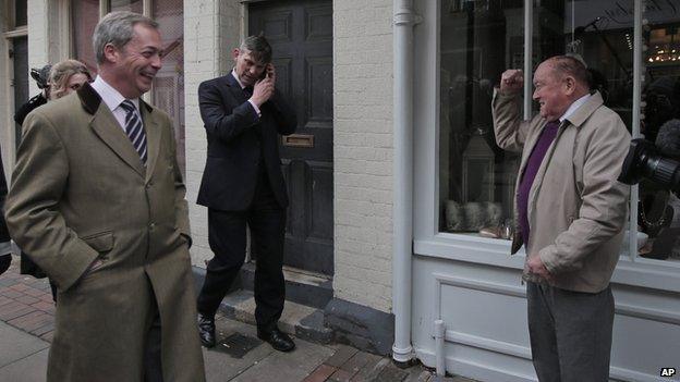 Nigel Farage walks past a supporter in Rochester, Kent