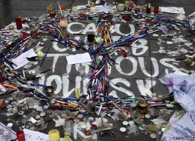 Pens and candles left in tribute