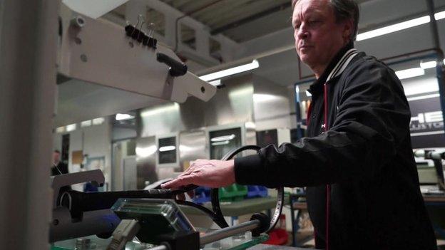 Head factory employee assesses a racquet