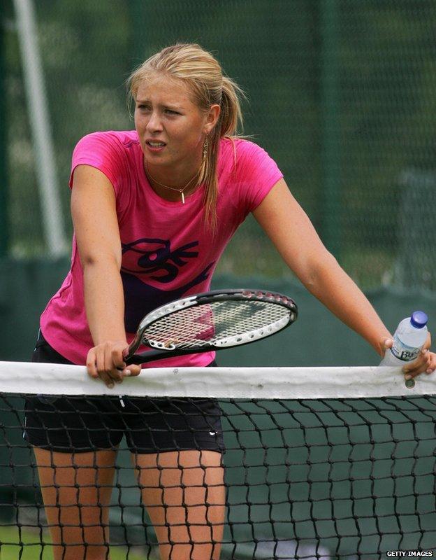 Maria Sharapova rests on a tennis net during training in London