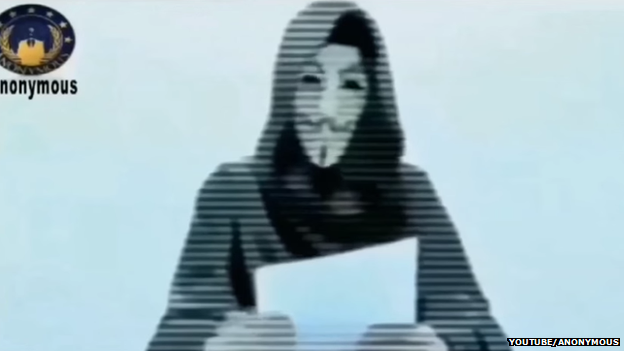 A hooded and masked man reads out a statement