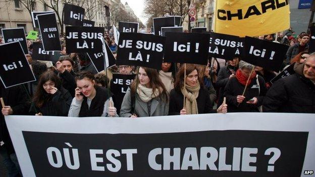 People walk behind a banner reading "Where is Charlie?" holding placards reading "I am here" take part in a Unity rally Marche Republicaine at the Place de la Republique in Paris, 11 January 2015