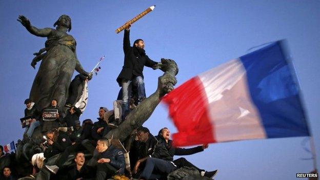 A man holds a giant pencil as he takes part in a solidarity march (Marche Republicaine) in the streets of Paris, 11 January 2015