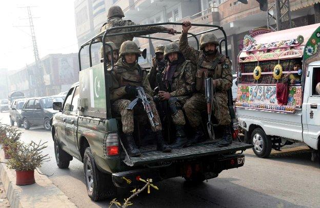 Pakistani soldiers provide security during a mass prayer for the victims of a school massacre, in Peshawar - 21 December 2014