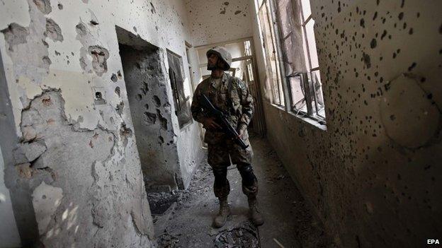 A Pakistani army soldier looks at a bullet ridden wall of the Army Public School, attacked by Taliban militants in Peshawar - 18 December 2014