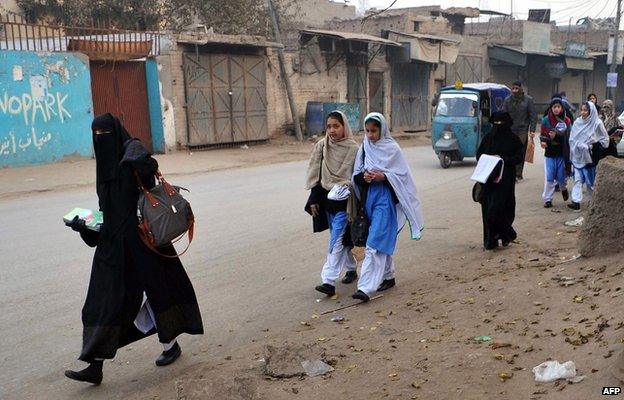 Pakistani students walk to school after schools in the city reopened following a Taliban attack in Peshawar on January 12, 2015