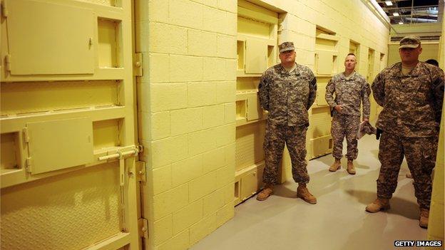 US soldiers stand guard beside prison cells during a media tour of Bagram prison, north of Kabul, on 15 November 2009.