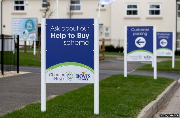 Signs outside newly built homes read "Ask about our Help To Buy scheme"