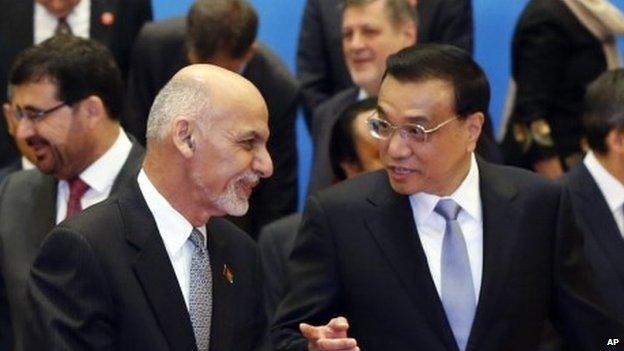 Chinese Premier Li Keqiang, front right, and Afghan President Ashraf Ghani Ahmadzai , front left, talk after posing for a group photo with other participants of the 4th Ministerial Conference of Istanbul Process of Afghanistan, at the Diaoyutai State Guesthouse in Beijing, China Friday, Oct. 31, 2014.