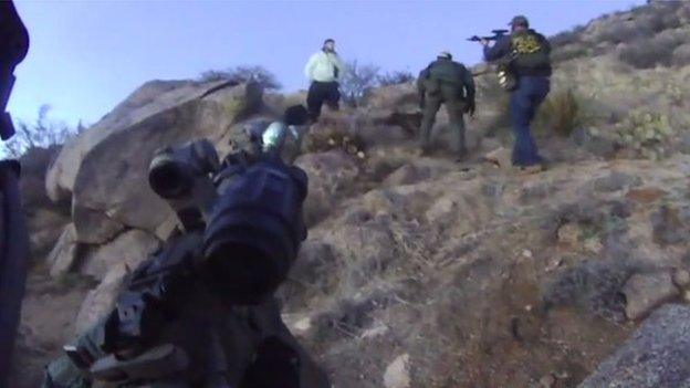 Police officers point their guns at a camper