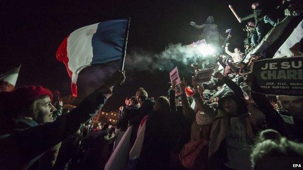 People gather around the monument on Place de la Nation as millions of people march against terrorism in Paris, France, 11 January 2015.