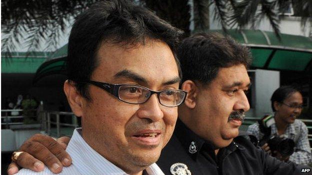 Abdul Razak Baginda, a high-profile political analyst (L) walks towards the court room in police custody in Shah Alam, west of Kuala Lumpur on 31 October 2008.