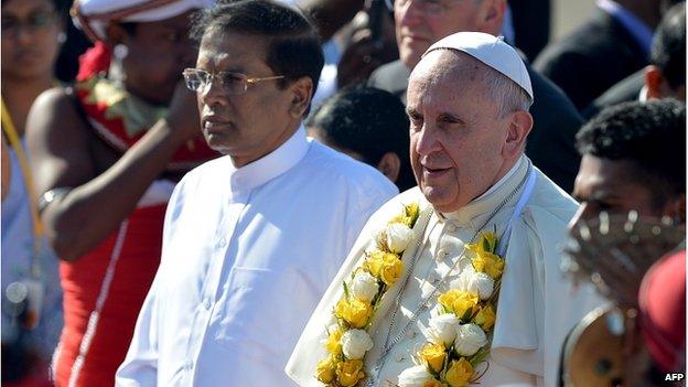 Pope Francis (R) gestures alongside Sri Lankan President Maithripala Sirisena (L) during a welcome ceremony at the Bandaranaike International Airport in Katunayake on 13 January 2015.