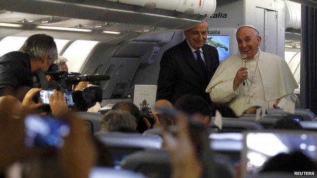 Pope Francis entertains reporters on an airplane