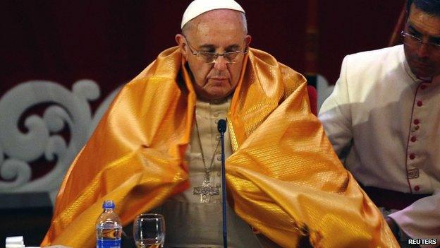 Pope Francis wears a saffron robe during a multi-faith meeting in Sri Lanka