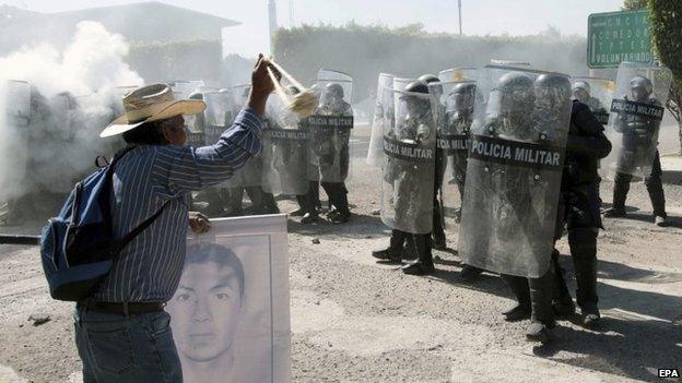 Relatives of the 43 missing Mexican students clash with police as they try to enter army facilities in Iguala on 12 January 2014