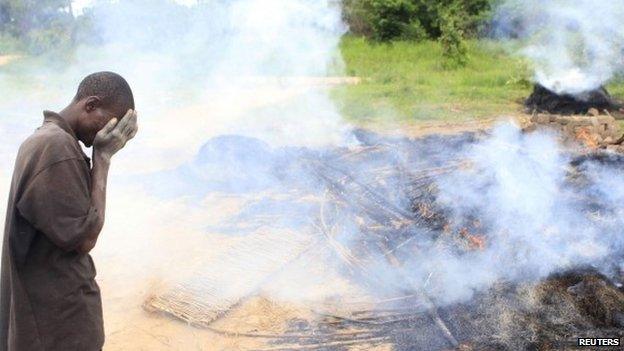 A Zimbabwean villager weeps in front of burning and demolished makeshift shelters at Manzou Farm in Mazowe - 8 January 2015