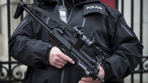 An armed police officer patrols on Whitehall on 12 January 2015