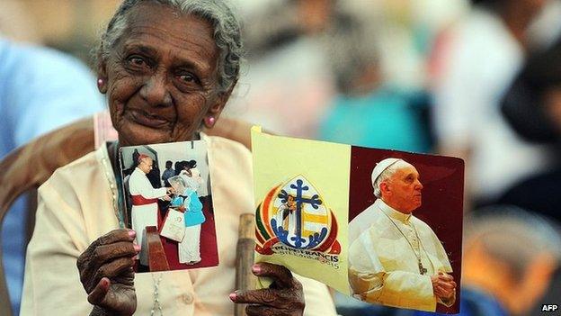 A Sri Lankan Catholic devotee holds a flag bearing the portrait of Pope Francis a day before the celebration of the Papal Mass by Pope Francis in the capital Colombo on 13 January 2015