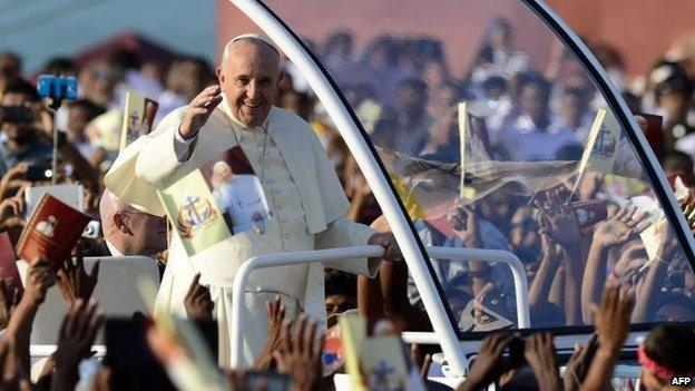 Pope Francis (C) waves to people as he arrives to lead a mass in the capital Colombo on 14 January 2015