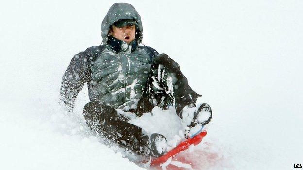 A man riding a sledge in the snow