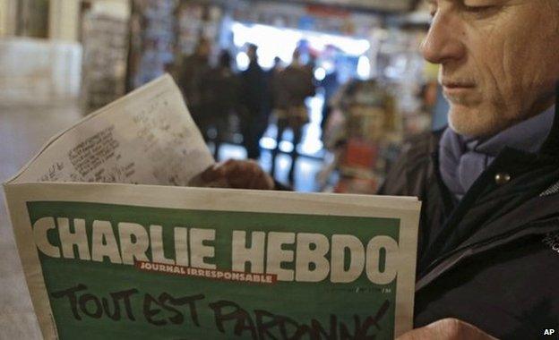 Jean Paul Bierlein reads the new Charlie Hebdo outside a newsstand in Nice, south-eastern France, 14 January 2015