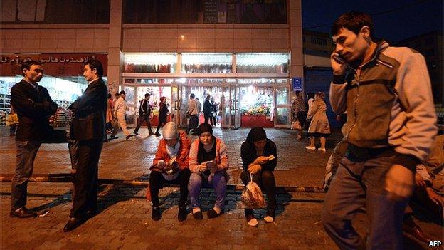 This picture taken on 17 September 2014 shows young Uighurs resting near the Grand Bazaar in Urumqi, far west China's Xinjiang region.