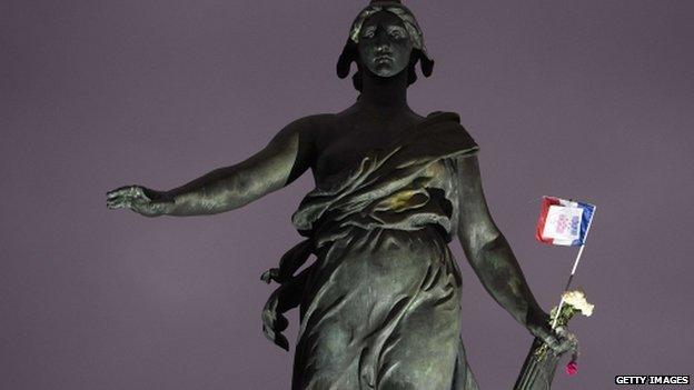 A French flag hung at the statue named "Le triomphe de la Republique" in the Place de la Nation