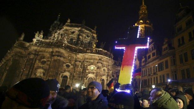 Participants hold a cross painted in the colours of German national flag during a demonstration called by anti-immigration group Pegida