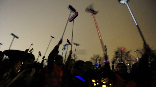 Anti-Pegida demonstrators perform a broom-dance to protest against a rally by the movement in Dresden