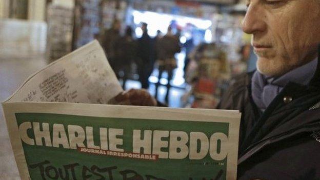 Jean Paul Bierlein reads the new Charlie Hebdo outside a newsstand in Nice, south-eastern France, 14 January 2015