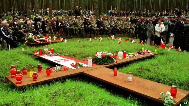 People prepare for the memorial ceremony on the site of the mass graves in the village of Katyn in western Russia