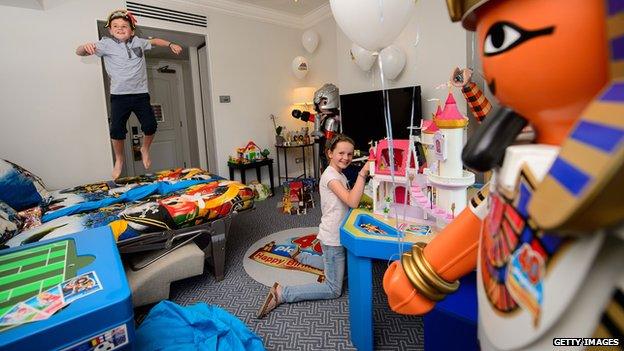 Children playing in a room full of toys