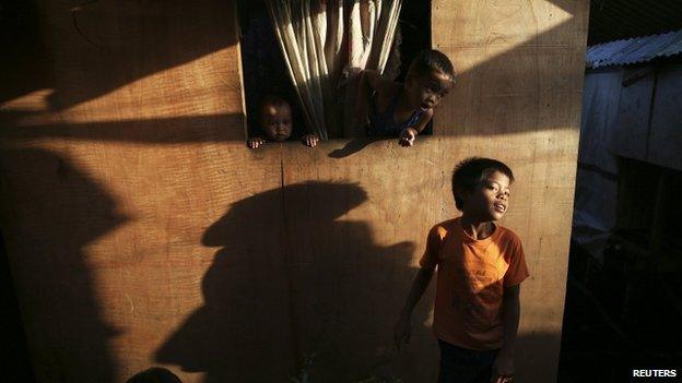 Children play between makeshift houses in the coastal part of Tacloban that was destroyed by Typhoon Haiyan