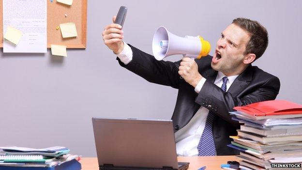 man uses megaphone to shout at phone