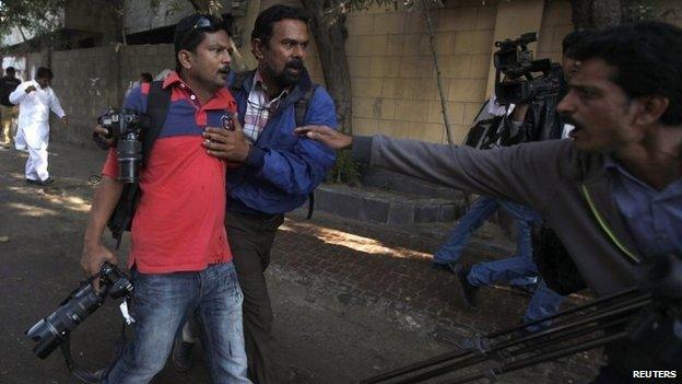 Asif Hassan (L), shot during a protest against satirical French weekly Charlie Hebdo, is helped by a fellow photographer in Karachi January 16,