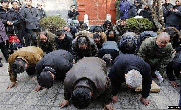 Mourners bow on the ground as they mourn for Zhao Ziyang on the 10th anniversary of his death at his house in Beijing 17 January 2015