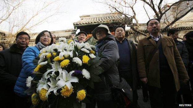 Mourners bring a bouquet of flowers as they visit the house of Zhao Ziyang on the 10th anniversary of his death in Beijing, 17 January 2015