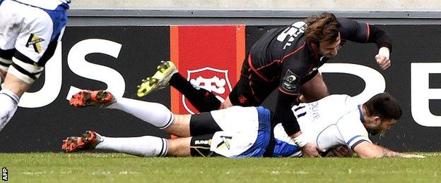 Matt Banahan scores for Bath despite the attempted tackle of Toulouse full-back Maxime Medard