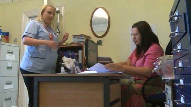 A care worker visits her office