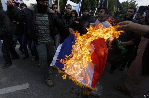 A Palestinian demonstrator burns a French flag in Gaza City, 19 January