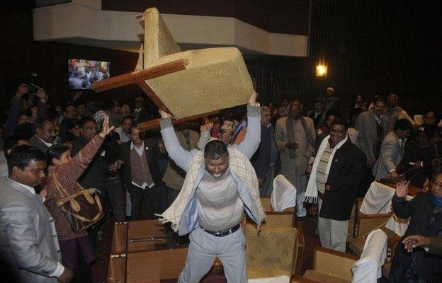 A constitution assembly member of an opposition party throws a chair during a meeting inside the Constitution Assembly building in Kathmandu January 20, 2015.