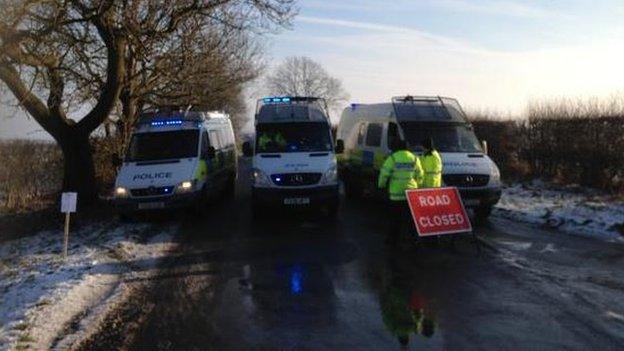 Police vehicles block road to Crawberry Hill protest camp