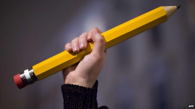 Free speech campaigner holds up pencil during pro Charlie Hebdo march