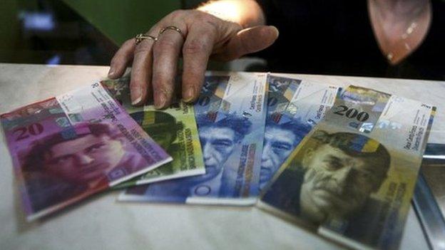 Cashier at currency exchange office in Warsaw with Swiss Francs