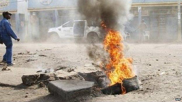 A man walks past a tyre set alight during a nation-wide protest as opposition parties tried to block a change in the law that may delay elections, in Goma eastern Democratic Republic of Congo (19 January 2015)