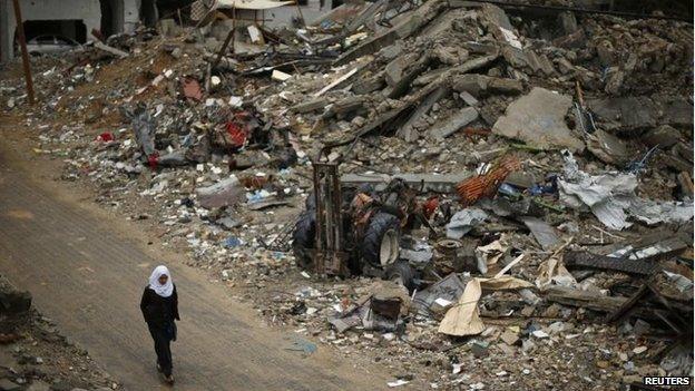 File photo: A Palestinian school girl walks past the ruins of houses that witnesses said were destroyed by Israeli shelling during the most recent conflict between Israel and Hamas, in the northern Gaza Strip, 23 November 2014